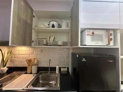 a kitchen with a sink and a microwave at Ustays in comfort and style in Manila