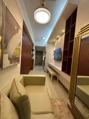 a living room with a couch and a chandelier at Ustays in comfort and style in Manila