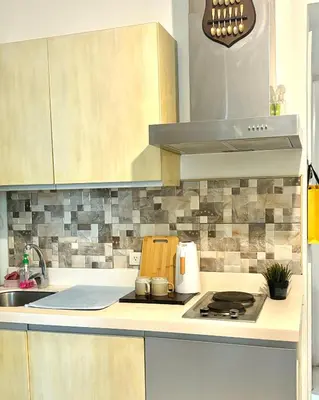a kitchen with a sink and a stove top oven at Metroshore Azure 2 in Manila