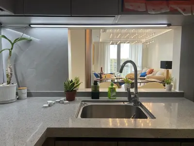 a kitchen with a sink and a living room at Luxurious Modern Penthouse 2BR Cross City of Dreams OKADA SOLAIRE MOA Airports in Manila