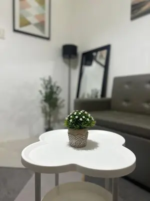 a white coffee table with a potted plant on it at Minamalist modern Condo with Chic touches 