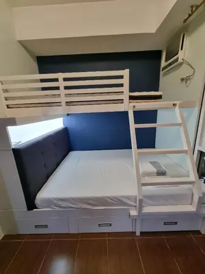 a bunk bed with white bunk beds in a room at AD Camp in Manila