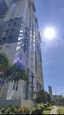 a tall apartment building with the sun in the background at AD Camp in Manila