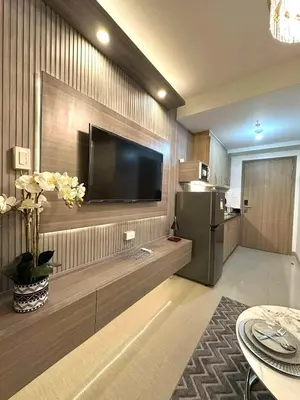 a living room with a flat screen tv on a wall at Shore 2 Residences, 1BR Balcony - Pool view in Manila