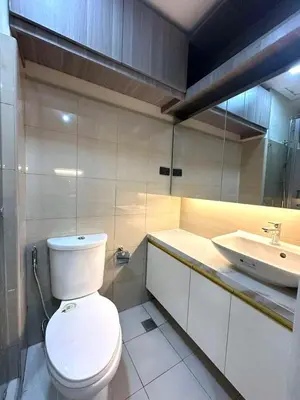 a bathroom with a toilet and a sink at Shore 2 Residences, 1BR Balcony - Pool view in Manila
