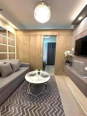 a living room with a couch and a table at Shore 2 Residences, 1BR Balcony - Pool view in Manila