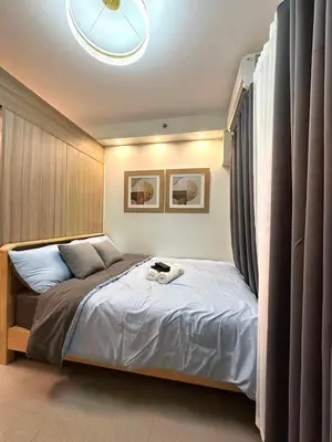 a bedroom with a bed with a clock on it at Shore 2 Residences, 1BR Balcony - Pool view in Manila