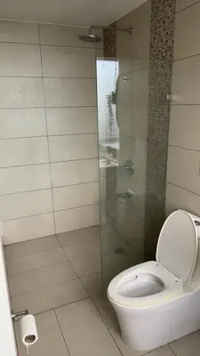 a bathroom with a toilet and a glass shower at UG108 Oak Harbor in Manila