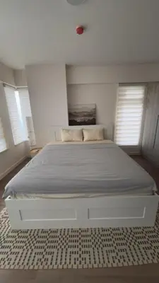 a white bed in a bedroom with windows at UG108 Oak Harbor in Manila
