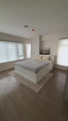 a bedroom with a large bed and two windows at UG108 Oak Harbor in Manila