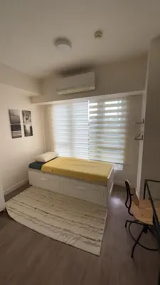a bedroom with a bed and a window with blinds at UG108 Oak Harbor in Manila