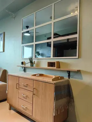 a room with a wooden cabinet and a large window at Condo Unit at SMDC Breeze Residences with a view in Manila