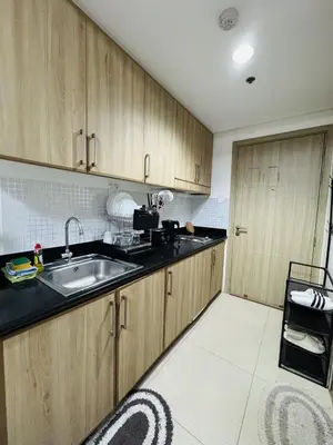 a kitchen with wooden cabinets and a sink at Shore Oasis Manila Near Mall of Asia in Manila