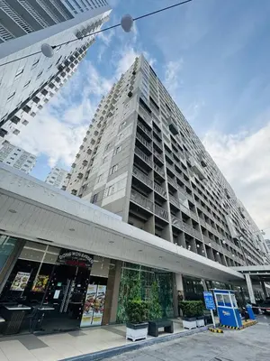 a tall building with a store in front of it at Shore Oasis Manila Near Mall of Asia in Manila