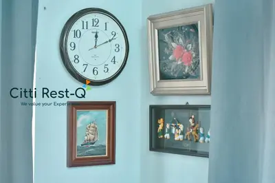 a clock hanging on a wall with framed pictures at Studio City Alabang Pool Access Free for 2 Wifi & Netflix SC3 in Manila