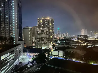 a city skyline at night with tall buildings at Welcome to Jade Place at Pioneer Woodlands in Manila