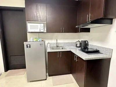 a kitchen with a refrigerator and a sink at Welcome to Jade Place at Pioneer Woodlands in Manila