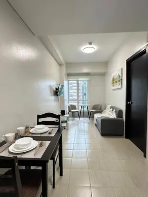 a living room with a table and a couch at Welcome to Jade Place at Pioneer Woodlands in Manila
