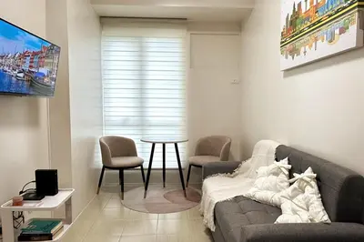 a living room with a couch and a table at Welcome to Jade Place at Pioneer Woodlands in Manila