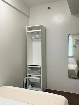 a bedroom with a closet with a mirror and a bed at Welcome to Jade Place at Pioneer Woodlands in Manila