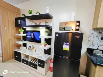 a kitchen with a refrigerator and a counter with a desk at Santorini Suite Manila-Mall of Asia in Manila
