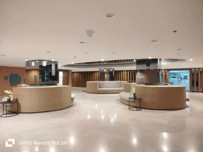 a lobby with couches and tables in a building at Santorini Suite Manila-Mall of Asia in Manila