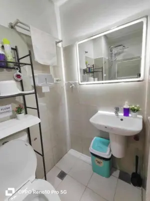 a bathroom with a sink and a toilet and a mirror at Santorini Suite Manila-Mall of Asia in Manila