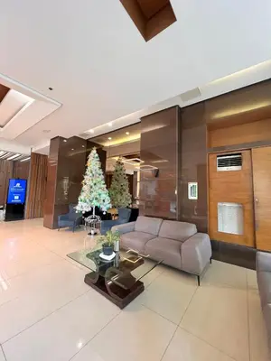 a living room with a couch and a christmas tree at Sunset Studio in Manila