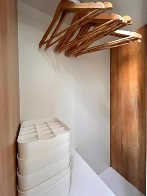 a room with a white stool and a wooden shelf at Sunset Studio in Manila