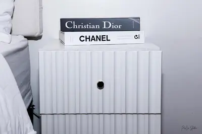 a stack of books on top of a white radiator at On Promo Condo 1BR Makati in Manila
