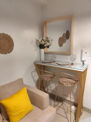 a living room with a table and a couch at Comfort Cove PH in Manila