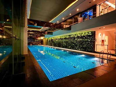 a large swimming pool in a building at night at GRAMERCY - SKY-VIEW 1 Bed escape with POOL & SPA Access in Manila