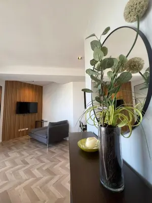 a vase with flowers on a table in a living room at GRAMERCY - SKY-VIEW 1 Bed escape with POOL & SPA Access in Manila