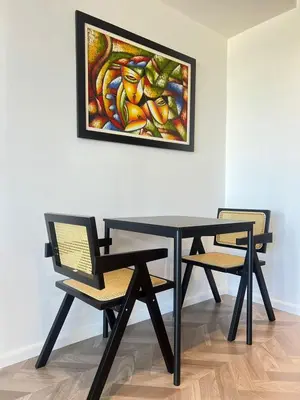 a table with two chairs and a painting on the wall at GRAMERCY - SKY-VIEW 1 Bed escape with POOL & SPA Access in Manila