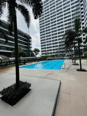 a large swimming pool in a city with tall buildings at Bali Inspired near BGC and NAIA in Manila