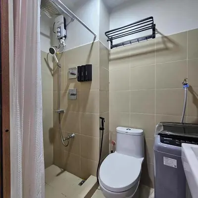 a bathroom with a shower with a toilet and a sink at Cozy Minimalist Unit at SMDC Shore 3 in Manila