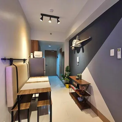 a room with a kitchen with a table and a refrigerator at Cozy Minimalist Unit at SMDC Shore 3 in Manila