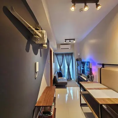 a living room with a couch and a tv and aoustic at Cozy Minimalist Unit at SMDC Shore 3 in Manila