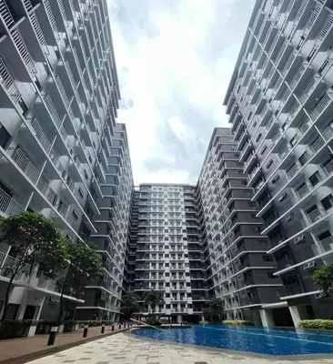 a large apartment building with a pool in front of it at Cozy Minimalist Unit at SMDC Shore 3 in Manila
