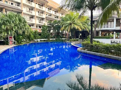 a large blue swimming pool in front of a building at Siena Park by Casa Stellar Bicutan Paranaque in Manila