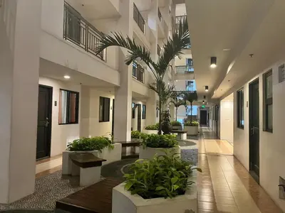 a hallway of a building with benches and plants at Siena Park by Casa Stellar Bicutan Paranaque in Manila