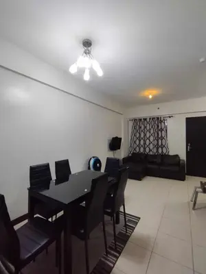 a dining room with a table and chairs and a couch at Siena Park by Casa Stellar Bicutan Paranaque in Manila