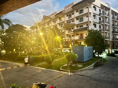 a person walking in a parking lot in front of a building at Siena Park by Casa Stellar Bicutan Paranaque in Manila