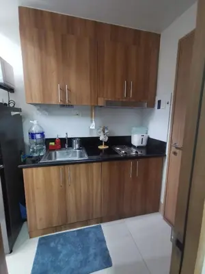 a kitchen with wooden cabinets and a sink at aldo shore 3 residence mall of asia in Manila