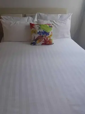a white bed with a pillow on top of it at Urban Escape- SM Jazz Residences in Manila
