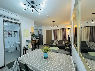 a kitchen and living room with a table and a couch at Cozy 2-BR Perfect for Families and Friends in Manila