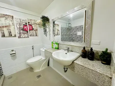 a bathroom with a sink and a toilet and a mirror at Cozy 2-BR Perfect for Families and Friends in Manila