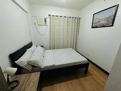 a small bedroom with a bed in a room at Cozy 2-BR Perfect for Families and Friends in Manila