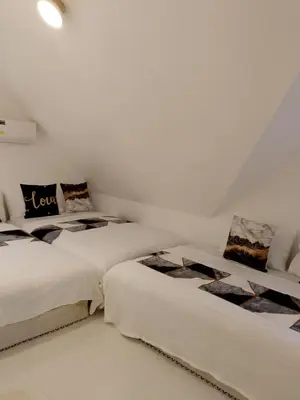 two beds in a room with white walls at Montalban Villa in General Trias