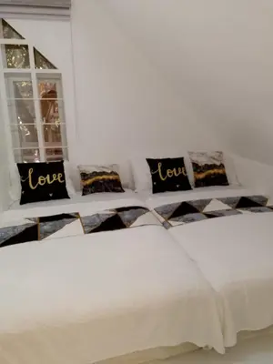 a white bedroom with two beds with love pillows at Montalban Villa in General Trias